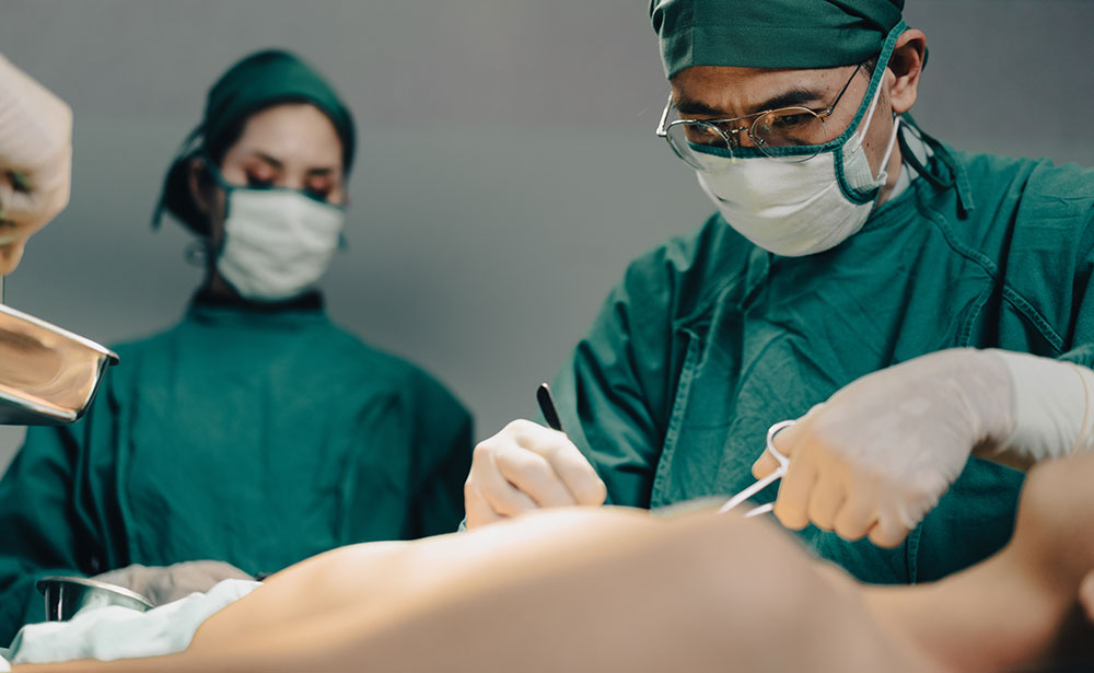 Das medizinische Team für Wiederbelebung führt chirurgische Eingriffe im Operationssaal durch. Gruppe von Chirurgen, die ernsthaft daran arbeiten, das Leben von Patienten im Krankenhaustheater zu retten.